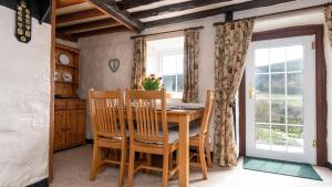 Un comedor con mesa y sillas y una ventana. en Maes Glas, en Mallwyd