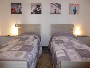 two beds in a room with posters on the wall at La Casa Del Merlo by Holiday World in Sestri Levante