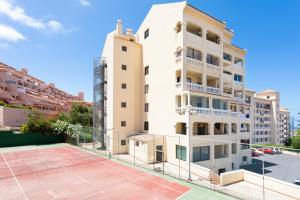a building with a tennis court in front of it at Tropic Apartments en Castle harbour in Los Cristianos