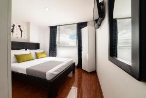 Un dormitorio con una cama y dos ventanas en Hotel Dorado 100, en Bogotá 17 fotos más