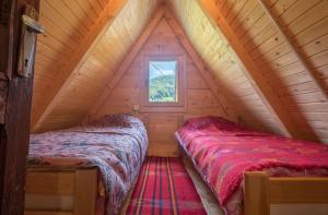 2 camas en un ático de madera con ventana en Forest fruit Jelovica en Berane