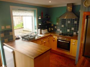 a kitchen with a sink and a stove at Arivonie Lochside Cottage in Glencoe
