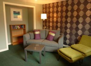 un soggiorno con divano e tavolo di Arivonie Lochside Cottage a Glencoe