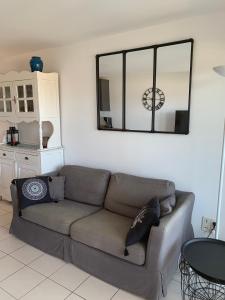 a living room with a couch and a mirror at Appartement 4 personnes, vue mer exceptionnelle sur le golf de St Tropez in Saint-Tropez