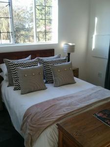 - une chambre avec un grand lit et des oreillers dans l'établissement 4 On Braemar - Flat B, à Nottingham Road