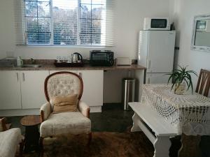 a kitchen with a chair and a table and a refrigerator at 4 On Braemar - Flat B in Nottingham Road