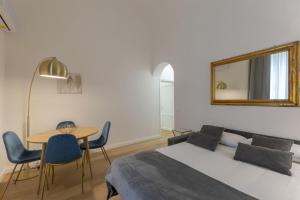 a bedroom with a bed and a table and a mirror at FLORENCE FIORINO APARTMENT in Florence