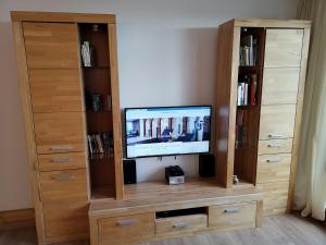 ein hölzernes Unterhaltungszentrum mit einem TV und Bücherregalen in der Unterkunft Waldwipfel-Appartement in Sankt Englmar