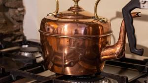 a copper tea kettle sitting on top of a stove at White O Morn in Conwy