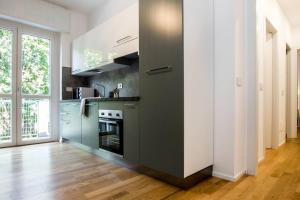 a kitchen with a black and white kitchen at ALTIDO Fresh Family Apt for 5 near City Life in Milan
