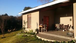 a house with a patio and a table and chairs at 4 On Braemar - Flat B in Nottingham Road
