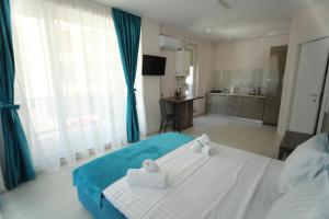 een slaapkamer met een groot bed en handdoeken bij Sammos Black Sea Apartments in Mamaia Nord – Năvodari