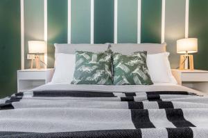 um quarto com uma cama com paredes verdes e 2 candeeiros em JOIVY Fresh Family Apt for 5 near City Life em Milão