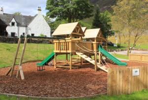 a playground with a slide and a play structure at Birch Chalet in Ballachulish