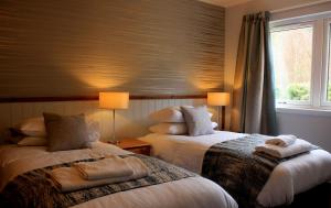 una camera d'albergo con due letti e una finestra di Hawthorn Cottage a Glencoe