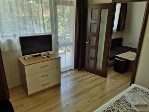 a bedroom with a tv and a dresser with a televisionictericter at Guest House Sv Nikola in Ahtopol