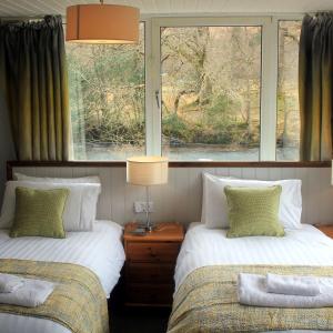 twee bedden in een kamer met twee ramen bij Hawthorn Cottage in Glencoe