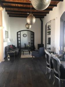 uma sala de estar com um sofá, uma mesa e cadeiras em Darcilla Guest House em Tarifa