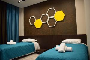 2 camas en una habitación de color amarillo y azul en BluePoint Hotel, en Kakavijë