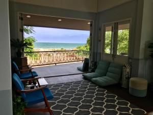 a living room with a couch and a view of the ocean at P.O.E Posh Homestay in Cha Am