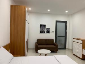 a bedroom with a bed and a couch and a chair at 319 Liên Phường, Q9 in Ho Chi Minh City