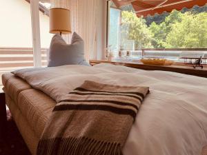 a bed with a blanket and a lamp on it at Black Forest Apartment in Bad Herrenalb