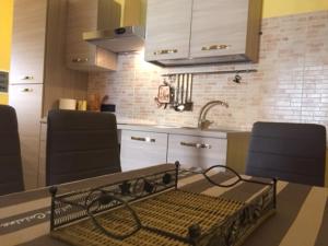 eine Küche mit 2 Stühlen und einer Theke mit einer Spüle in der Unterkunft Paradise Home in Quartu SantʼElena