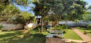 un banco sentado en el césped junto a un árbol en Alt House Qi 02 Lago Norte en Brasilia