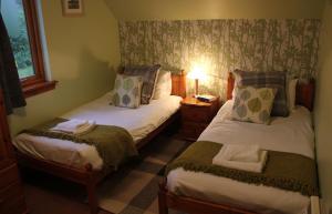mały pokój z 2 łóżkami i lampką w obiekcie No.2 Quarry Cottages w mieście Ballachulish