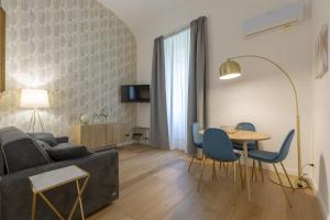 FLORENCE FIORINO APARTMENT في فلورنسا: غرفة معيشة مع أريكة وطاولة وكراسي