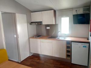 a small kitchen with white cabinets and a sink at Mira Lodge Park in Praia de Mira