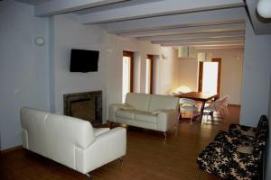 a living room with a white couch and a table at Country House Poggio Alto in Buonabitacolo