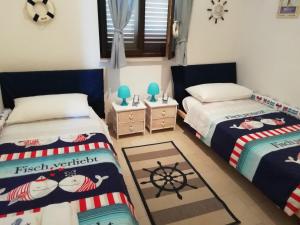 Un dormitorio con dos camas y una alfombra. en Villa Maria, en Carovigno