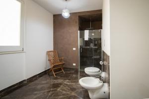 W łazience znajduje się toaleta, prysznic i krzesło. w obiekcie Villa Afrodite | Luxury Villa and Pool w mieście Custonaci +37 zdjęć