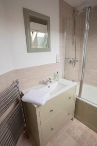 a bathroom with a sink and a shower with a mirror at Hook Cottage in Chipping Campden +16 photos