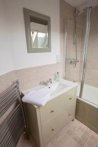 a bathroom with a sink and a shower with a mirror at Hook Cottage in Chipping Campden