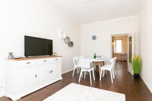 - un salon blanc avec une table et une télévision dans l'établissement Central Gonsiori, 2 bedroom, Cozy Apartment, à Tallinn