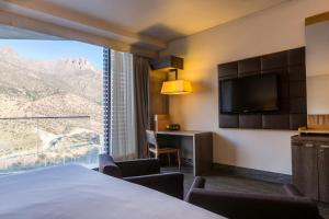 um quarto de hotel com uma cama e uma grande janela em Enjoy Santiago em Los Andes
