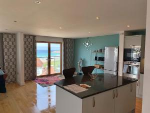a kitchen with a kitchen island with a view of the ocean at 4-bedroom Penthouse - Fistral Beach in Newquay
