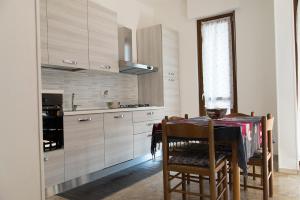 a kitchen with a table with chairs and a stove at Grande Bilocale in Alessandria