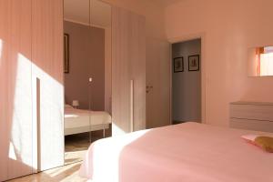Schlafzimmer mit einem weißen Bett und einem Spiegel in der Unterkunft Grande Bilocale in Alessandria