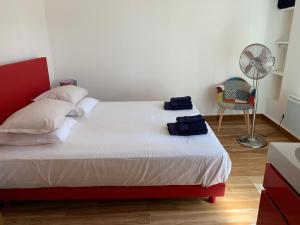 a bedroom with a red and white bed and a fan at LES CIGALES in L'Isle-sur-la-Sorgue