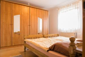 a bedroom with a bed with wooden cabinets and a window at Apartmani Ruza in Krasno Polje
