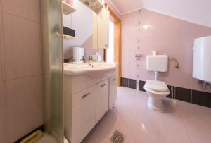 a bathroom with a white sink and a toilet at Apartmani Ruza in Krasno Polje