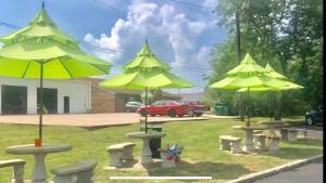 a group of tables with yellow umbrellas in a park at Super 8 by Wyndham Radcliff Ft. Knox Area in Radcliff