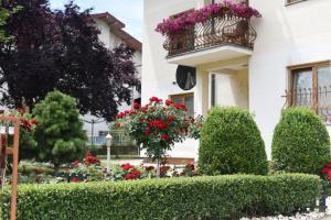 een wit gebouw met bloemen en een balkon bij Apartmani Boss in Vrnjačka Banja