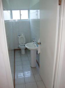 a bathroom with a toilet and a sink at Rowsvilla Guest House in Beau Vallon