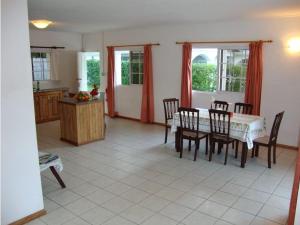 a kitchen and dining room with a table and chairs at Rowsvilla Guest House in Beau Vallon