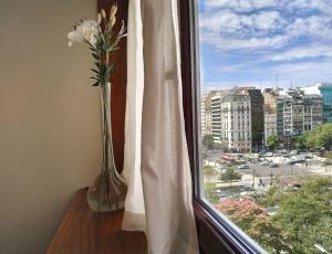 a vase with flowers sitting on a window sill at Hotel Presidente Buenos Aires in Buenos Aires