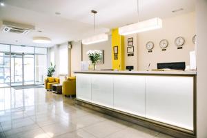 un vestíbulo de oficina con armarios blancos y detalles amarillos en Optima Vinnytsia en Vínnytsia